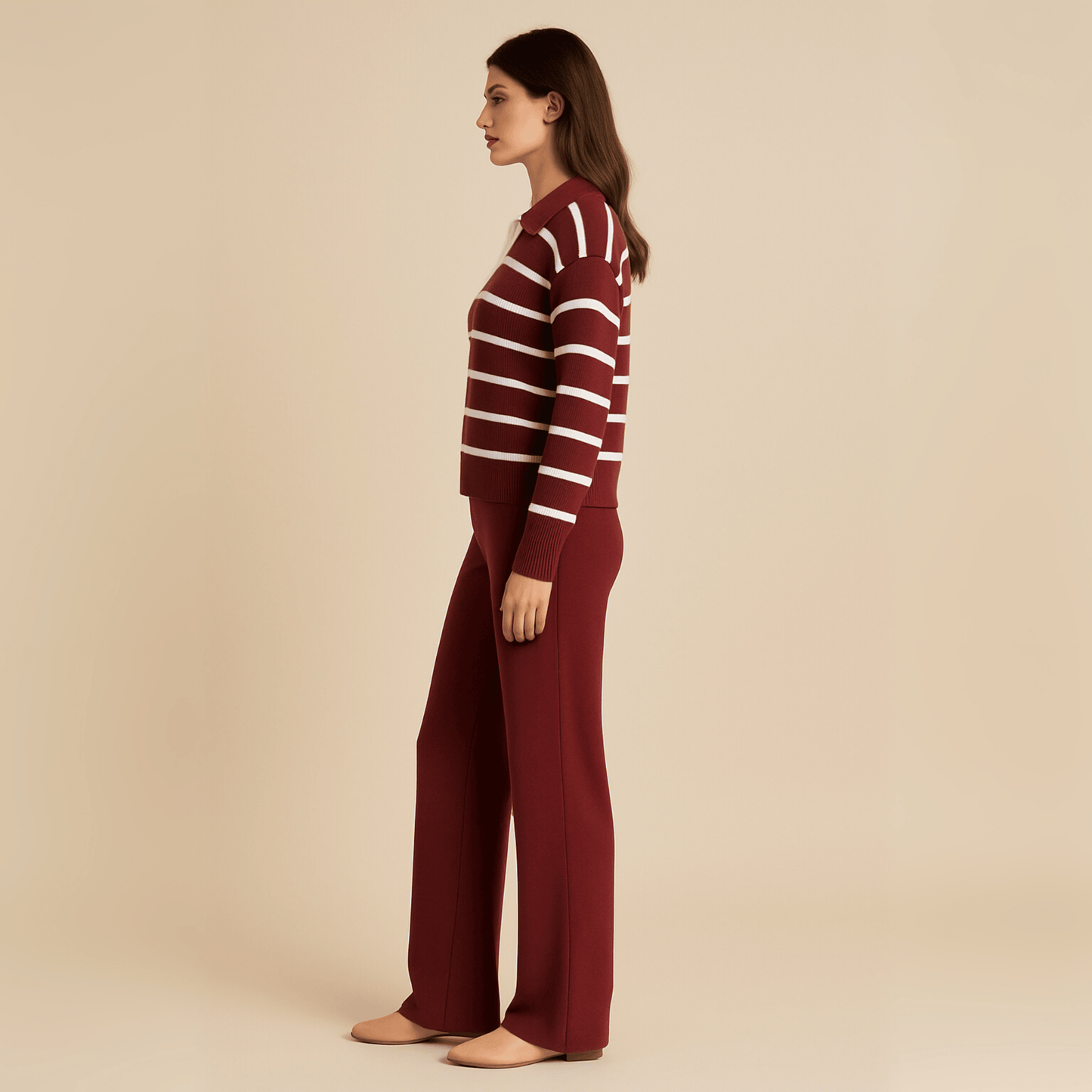 Woman wearing a maroon and white striped sweater with matching pants on a beige background