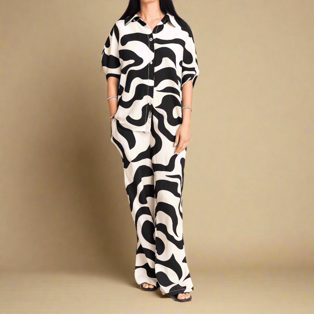 Person wearing a black and white patterned outfit on a beige background