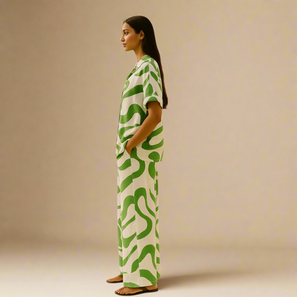  Modern Dynasty’s Moolit Majesty green and white co-ord, consisting of a breezy, short-sleeved shirt and wide-leg pants adorned with bold, abstract green swirls.